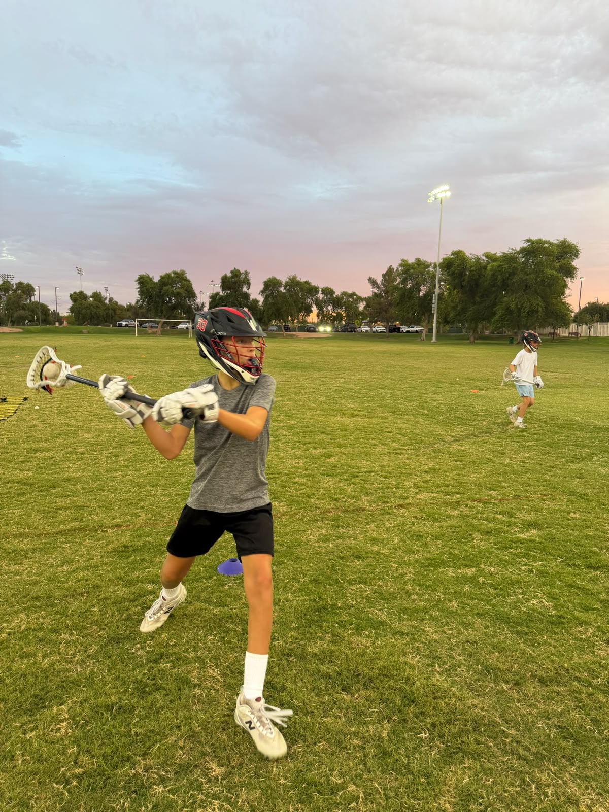 A Valley Boys athlete practicing a lacrosse shot on the field